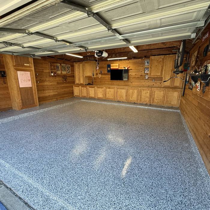 Gray flake epoxy floor in a wood paneled garage