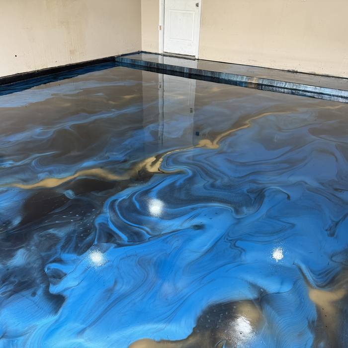 Blue and gold metallic epoxy floor stretching across a garage