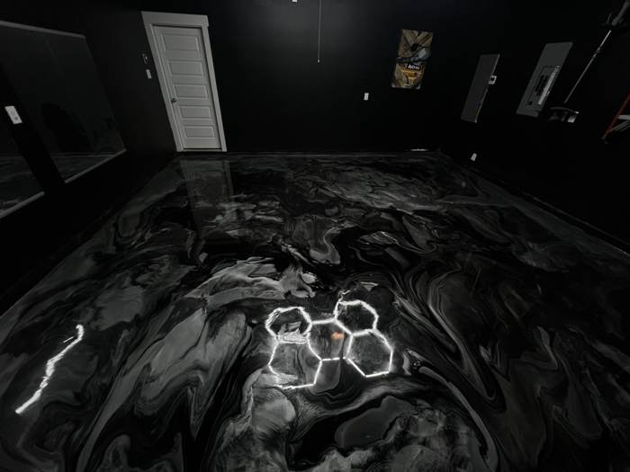 Black metallic epoxy showroom floor with glowing hexagon lights